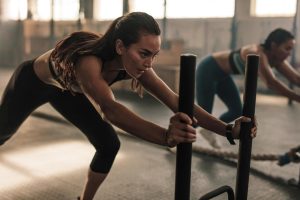 Deux femmes sportives réalisant l’exercice power sled.